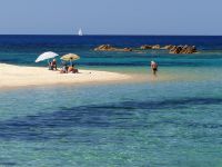 Vom Strand blickt man auf kleine, felsige Inseln.